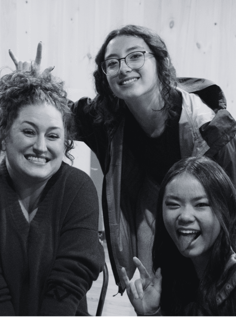 three Prisma learning coaches smiling and laughing together in black and white photo